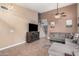 Living room with a large sectional sofa, tile floors, entertainment center, and staircase at 12574 W Desert Rose Rd, Avondale, AZ 85392