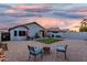 Lush backyard with gravel landscaping, a faux lawn patch, and a charming seating area with fire pit at 12630 W Aster Dr, El Mirage, AZ 85335