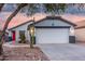 Charming single-story home featuring a two-car garage, desert landscaping, and a bright red front door at 12630 W Aster Dr, El Mirage, AZ 85335