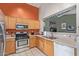 Bright kitchen featuring stainless steel appliances, light wood cabinetry, and ample counter space for meal preparation at 12630 W Aster Dr, El Mirage, AZ 85335