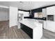 Modern kitchen featuring white cabinets, stainless steel appliances, a spacious center island, and sleek backsplash at 1321 E Pedro Rd, Phoenix, AZ 85042