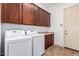 Laundry room features front loading washer and dryer, cabinets, and tile floor at 13344 W Via Caballo Blanco --, Peoria, AZ 85383