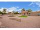 Spacious backyard with desert landscaping, fire pit, and artificial turf area at 1365 N El Dorado Dr, Chandler, AZ 85224