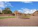 Expansive backyard featuring a putting green, fire pit, covered patio, and desert landscaping at 1365 N El Dorado Dr, Chandler, AZ 85224