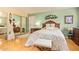 Bright bedroom featuring a large bed, wood floors, and sliding mirror closet doors at 1365 N El Dorado Dr, Chandler, AZ 85224