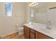 Bright bathroom featuring a double sink vanity, tiled floor and a window for natural light at 13672 W Chaparosa Way, Peoria, AZ 85383