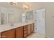 Bright bathroom featuring double sinks, modern lighting, and a separate toilet room at 13672 W Chaparosa Way, Peoria, AZ 85383