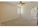 Bright bedroom featuring carpet, neutral walls, fan, and a view into the hall at 13672 W Chaparosa Way, Peoria, AZ 85383