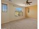 Spacious bedroom with carpet, ceiling fan, and windows overlooking the desert landscape at 13672 W Chaparosa Way, Peoria, AZ 85383