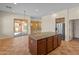 Kitchen showcases a center island with granite countertops that compliments the stainless steel refrigerator at 13672 W Chaparosa Way, Peoria, AZ 85383