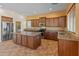 Well-lit kitchen features stainless steel appliances, granite countertops, an island, and rich wood cabinetry at 13672 W Chaparosa Way, Peoria, AZ 85383