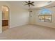 Spacious main bedroom with large arched window, carpet, and adjoining main bathroom at 13672 W Chaparosa Way, Peoria, AZ 85383