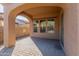 Covered patio with brick flooring and stone wall in the background at 13672 W Chaparosa Way, Peoria, AZ 85383