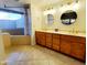 Bathroom with dual sinks, wood cabinets, and tile flooring at 1606 E Cactus Wren Dr, Phoenix, AZ 85020