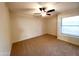 Standard carpeted bedroom with a ceiling fan and a window at 1606 E Cactus Wren Dr, Phoenix, AZ 85020