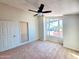 This bedroom features a ceiling fan, carpet flooring and view to the outdoors at 1606 E Cactus Wren Dr, Phoenix, AZ 85020
