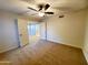 Carpeted bedroom with ceiling fan, window and open doorway to another room at 1606 E Cactus Wren Dr, Phoenix, AZ 85020