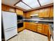 Kitchen area with appliances and ample wood cabinetry and tile floors at 1606 E Cactus Wren Dr, Phoenix, AZ 85020