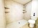 This bathroom shower is complete with tiled walls, shelves, and a hexagon-tiled floor at 1606 E Cactus Wren Dr, Phoenix, AZ 85020