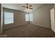 Spacious bedroom features plush carpet, ceiling fan, and natural light from multiple windows at 16125 W Lincoln St, Goodyear, AZ 85338