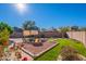 Backyard with a gravel fire pit surrounded by brick and flower gardens at 16671 W Mckinley St, Goodyear, AZ 85338