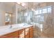 This bathroom is elegantly designed with a double vanity, large mirror, and walk-in shower at 16671 W Mckinley St, Goodyear, AZ 85338