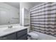 This bathroom offers a vanity, a mirror, and a shower with a stylish curtain at 16671 W Mckinley St, Goodyear, AZ 85338