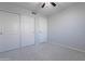 Bedroom with neutral walls, carpet floors, ceiling fan, closet and door with white trim at 16671 W Mckinley St, Goodyear, AZ 85338