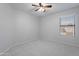 Bright bedroom features plush carpet, a ceiling fan, and a scenic view from the window at 16671 W Mckinley St, Goodyear, AZ 85338