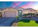 Charming single-story home with a two-car garage, desert landscaping and a colorful sunset sky at 16671 W Mckinley St, Goodyear, AZ 85338