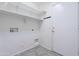 A laundry room with tile floors, white shelving, and a utility sink hookup at 16671 W Mckinley St, Goodyear, AZ 85338