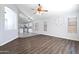 Open floor plan showing wood floors, a ceiling fan and the kitchen area beyond at 16671 W Mckinley St, Goodyear, AZ 85338