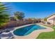 Backyard pool surrounded by turf and mature landscaping with view of nearby homes at 16671 W Mckinley St, Goodyear, AZ 85338