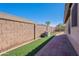 Clean and low-maintenance side yard with artificial turf and paver walkway at 16671 W Mckinley St, Goodyear, AZ 85338