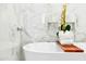 Bright bathroom features a soaking tub with waterfall faucet and marble tile surround at 17614 N 56Th Way, Scottsdale, AZ 85254