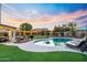 Backyard pool and putting green illuminated by charming string lights at twilight at 17614 N 56Th Way, Scottsdale, AZ 85254