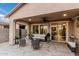 Relaxing covered back patio featuring plush seating, access to indoor kitchen and dining area at 17938 W Cedarwood Ln, Goodyear, AZ 85338