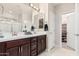 Bright bathroom featuring a double sink vanity with granite countertops and a separate shower at 17938 W Cedarwood Ln, Goodyear, AZ 85338
