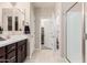 Well-lit bathroom showcasing a vanity, walk-in closet, and shower stall at 17938 W Cedarwood Ln, Goodyear, AZ 85338