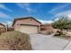 Exterior shot of home with concrete driveway, front yard landscaping, and an attached two-car garage at 17938 W Cedarwood Ln, Goodyear, AZ 85338