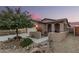 Charming single-story home featuring desert landscaping, a covered porch, and a two-car garage at 17938 W Cedarwood Ln, Goodyear, AZ 85338
