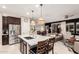 Open kitchen with island seating, stainless steel appliances, and seamless flow into living area at 17938 W Cedarwood Ln, Goodyear, AZ 85338