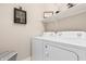 Convenient laundry area equipped with a washer, dryer, and overhead shelving for storage at 17938 W Cedarwood Ln, Goodyear, AZ 85338