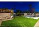 Spacious backyard featuring a pool, a covered patio with a lounge area and lush artificial turf at 1825 N Granite Reef Rd, Scottsdale, AZ 85257