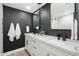 Modern bathroom with a double sink vanity, black accent wall and a large framed mirror at 1825 N Granite Reef Rd, Scottsdale, AZ 85257