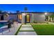 Home exterior with lush green lawn, accent lighting and a modern walkway to the front door at 1825 N Granite Reef Rd, Scottsdale, AZ 85257