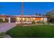 Charming single-story home with a well-manicured lawn, desert landscaping, and modern design elements at 1825 N Granite Reef Rd, Scottsdale, AZ 85257