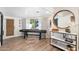 Spacious game room featuring a shuffleboard table, stylish bar area, and ample natural light at 1825 N Granite Reef Rd, Scottsdale, AZ 85257