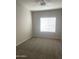 A bright bedroom with neutral walls, plush gray carpeting, and a window with blinds at 1920 E Bell Rd # 1188, Phoenix, AZ 85022