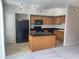 A spacious kitchen with an island, wooden cabinets, black countertops, and modern appliances at 1920 E Bell Rd # 1188, Phoenix, AZ 85022